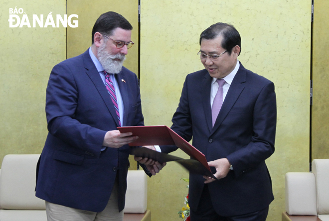 Chủ tịch UBND thành phố Huỳnh Đức Thơ (phải) và Thị trưởng William Mark Peduto trao thư chúc mừng.        Ảnh: LAM PHƯƠNG