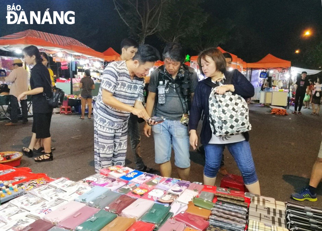 Các cơ sở dịch vụ du lịch cần nâng cao năng lực hướng đến đạt chuẩn phục vụ. TRONG ẢNH: Du khách mua sắm tại chợ đêm Sơn Trà.