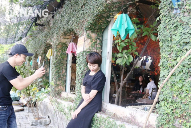 Visitors to the Ti Gon coffee shop like posing for photos with its green-completely covered arches