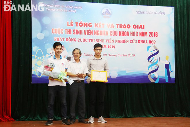 Ông Trần Văn Hoàng, Phó Giám đốc Sở Khoa học và Công nghệ Đà Nẵng, trưởng ban tổ chức cuộc thi (giữa) trao giải nhất cho đề tài “Máy in gốm 3D”.