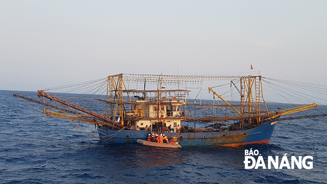 Rescuers transferring the victim from fishing boat QNa 90767 TS to their rescue ship SAR 412