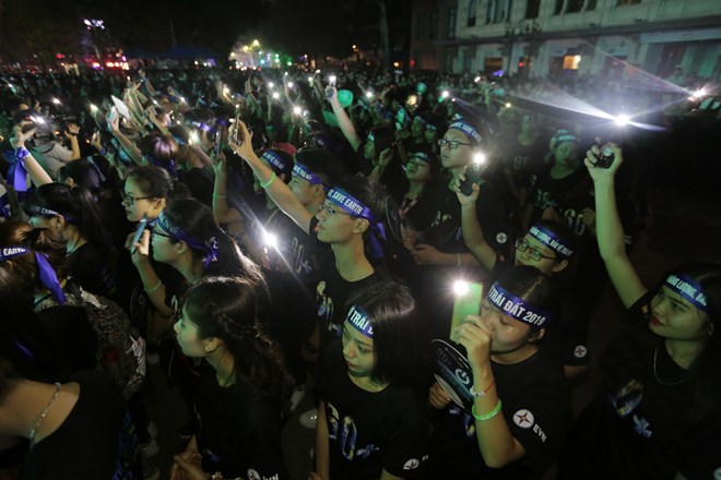 Young people take part in a ceremony responding to the Earth Hour campaign in Hanoi on March 30 evening
