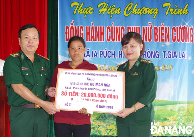 Đại tá Đỗ Văn Đông (trái), Phó Chính ủy Bộ đội Biên phòng Đà Nẵng trao kinh phí hỗ trợ sửa chữa nhà cho chị Rơ MaH Nga, xã Ia Puch, huyện Chư Prông (Gia Lai).