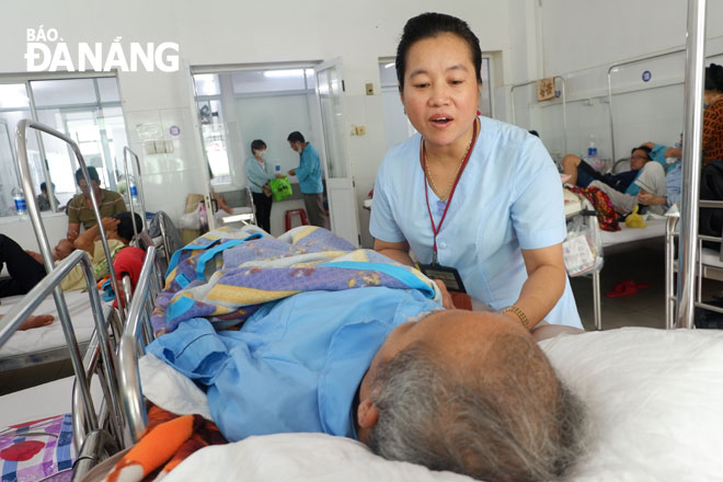 Chị Nguyễn Thị Xuân Hương, nhân viên phục vụ Khoa Nội hô hấp - Miễn dịch dị ứng, Bệnh viện Đà Nẵng đang hỏi thăm một nam bệnh nhân không thân nhân. 