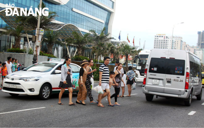 Áp lực về hạ tầng giao thông ngày càng tăng ở khu vực ven biển phía đông thành phố.  Trong ảnh: Du khách đi bộ qua đường Võ Nguyên Giáp.