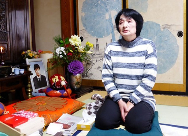 Bà Watanabe, một người có con trai tự tử, ngồi đau buồn bên cạnh bàn thờ con trai mình. Ảnh: Reuters