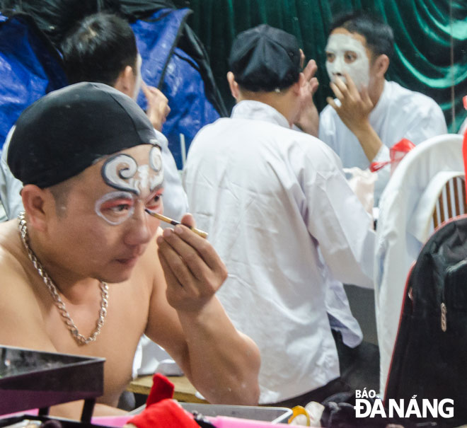 Some Tuong artistes drawing the masks for themselves before appearing on stage. It often takes them around one hour to do this work.