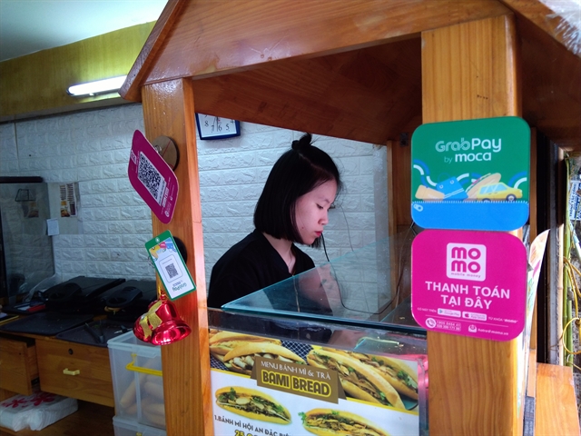 The signs of online payment service providers GrabPay and Momo displayed at a food store on Tran Hung Dao Street, Ha Noi.