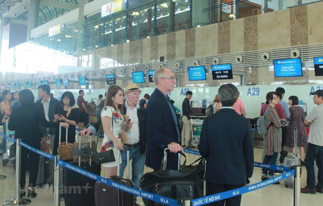 Hành khách làm thủ tục tại sân bay Nội Bài. (Ảnh: Vietnam+)