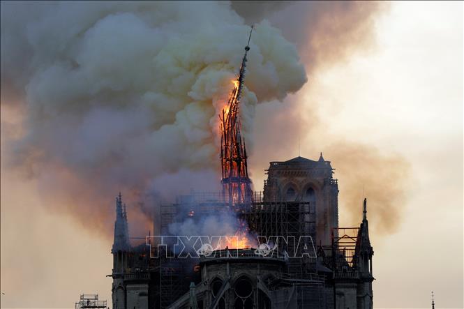 Ngọn tháp của Nhà thờ Đức Bà Paris đổ sập trong vụ hỏa hoạn ngày 15-4-2019. Ảnh: AFP/ TTXVN