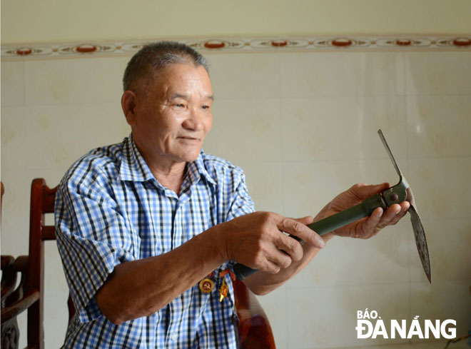 Ông Nguyễn Văn Sum với chiếc xẻng đa công dụng - kỷ vật thời đánh Mỹ.  Ảnh: LÊ VĂN THƠM