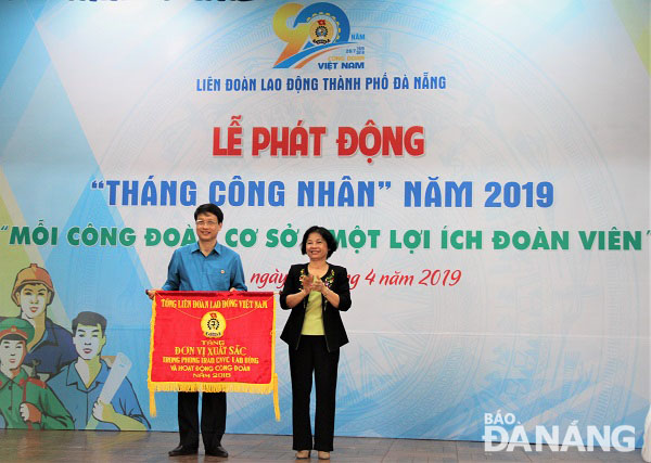 Chủ tịch Ủy ban MTTQ Việt Nam Đặng Thị Kim Liên (phải) trao cờ đơn vị xuất sắc cho LĐLĐ thành phố vì có thành tích xuất sắc trong phong trào công nhân viên chức lao động và hoạt động công đoàn năm 2018. Ảnh: Lam Phương