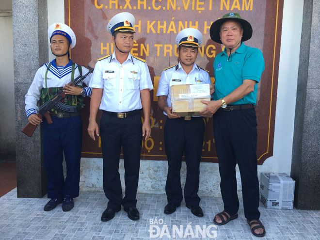 Tổng Biên tập Báo Đà Nẵng Trương Công Định (bìa phải)tặng quà cho cán bộ chiến sĩ huyện đảo Trường Sa. 