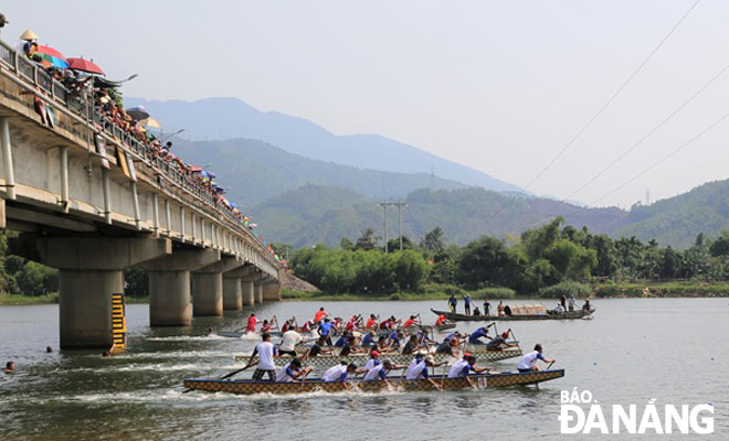 Hội đua thuyền của người dân Trường Định đoạn qua cây cầu cùng tên.     Ảnh: NHƯ HẠNH