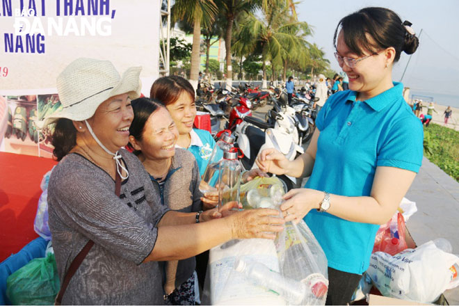 Phụ nữ quận Thanh Khê hào hứng với mô hình đổi rác thải nhựa lấy bình đựng nước bằng thủy tinh. Ảnh: THANH TÌNH