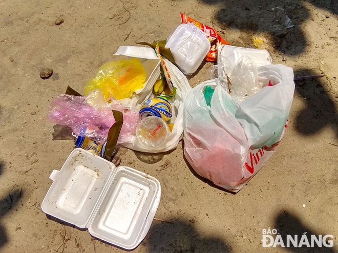 Rác thải sinh hoạt với ly nước, vỏ hộp bánh, hộp xốp... bỏ lại trên bãi biển Mỹ Khê sau một 