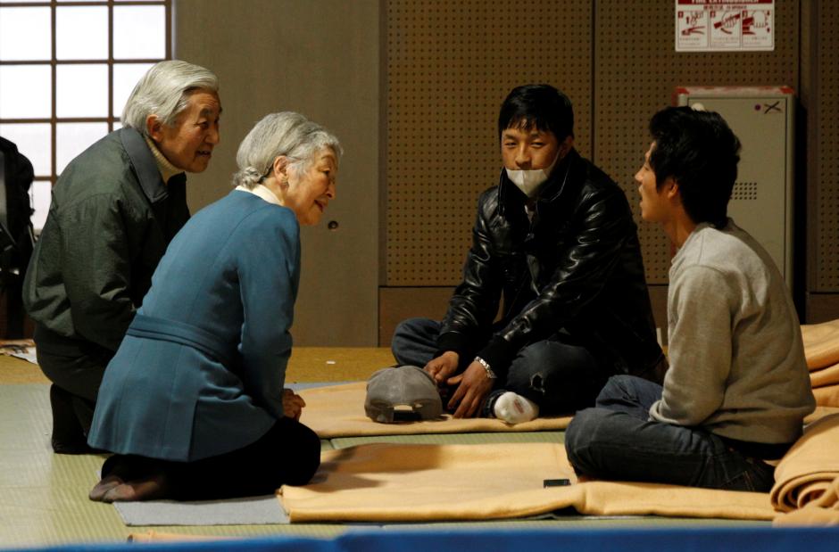Nhật hoàng Akihito và Hoàng hậu Michiko quỳ gối nói chuyện với nạn nhân động đất, sóng thần. Ảnh: Reuters
