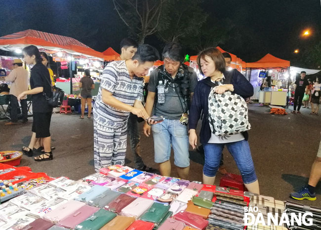 Du khách nước ngoài mua sắm tại chợ đêm Sơn Trà. 