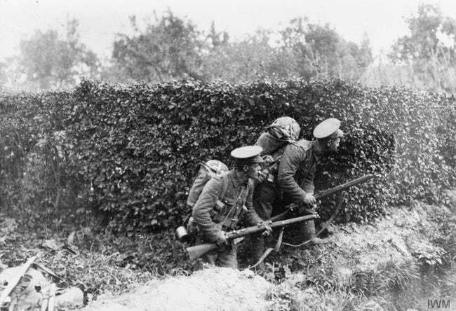 Hai người lính Anh đang nấp sau một hàng rào khi quân Đức xâm lược Bỉ năm 1914.