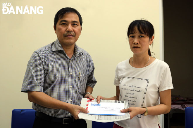 Deputy Editor-in-Chief Nam (left) handing cash donations to Thao's mother, and ...