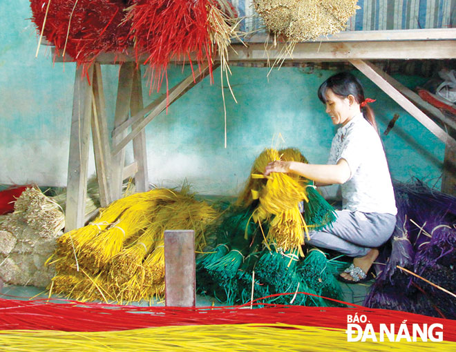 Chị Đặng Thị Thúy (44 tuổi) lấy những bó sợi cói nguyên liệu mang đi dệt.