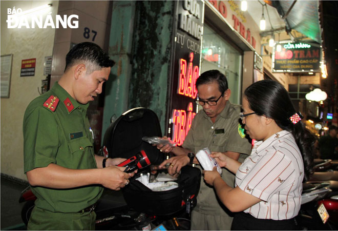 Bí thư Đảng ủy, Chủ tịch HĐND phường Hải Châu 1 Hoàng Giang Yên Thủy (bìa phải) và các thành viên trong Tổ sơ cấp cứu kiểm tra lại tủ thuốc y tế trước giờ đi tuần tra. 