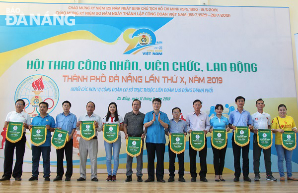 Chủ tịch LĐLĐ thành phố Ngô Xuân Thắng (gg) trao cờ lưu niệm cho các đội tham gia hội thao.