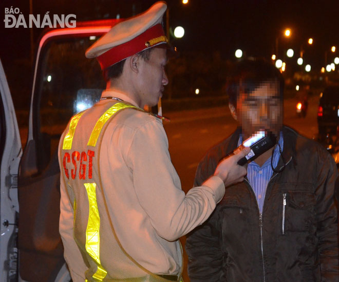 Lực lượng Cảnh sát giao thông đo nồng độ cồn đối với người điều khiển phương tiện giao thông tại đường Hoàng Thị Loan. 		                              Ảnh: NGỌC PHÚ