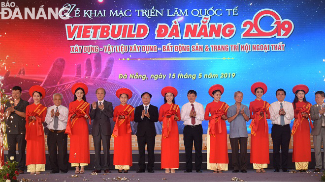 Phó Chủ tịch thường trực UBND thành phố Đặng Việt Dũng (áo trắng ở giữa) tham gia cắt băng khai mạc Triển lãm quốc tế Vietbuild Đà Nẵng 2019