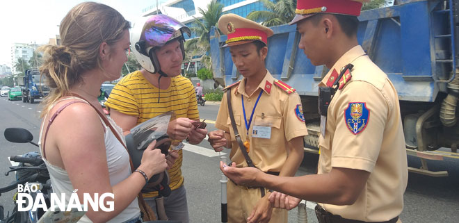 Cảnh sát giao thông kiểm tra giấy tờ phương tiện của du khách nước ngoài.