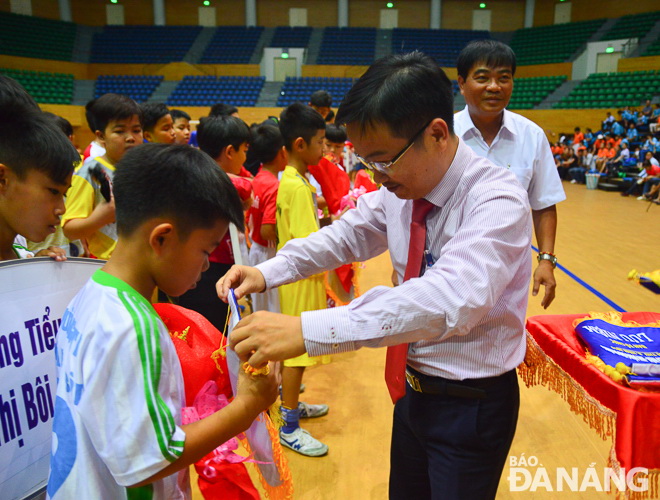 Mr Hai presenting flowers and souvenir flags to participating football and referee teams