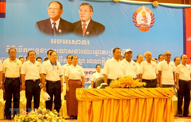 CPP officials salute the national flag at the event marking the beginning of the party's election campaign in Phnom Penh on May 17 (Photo: VNA)