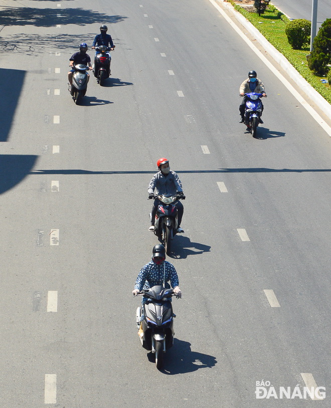 Road users are covered almost entirely from head to toe in combinations of helmets, sunglasses, facemasks, long sleeves, gloves, long pants, and socks to avoid the burning sunshine.