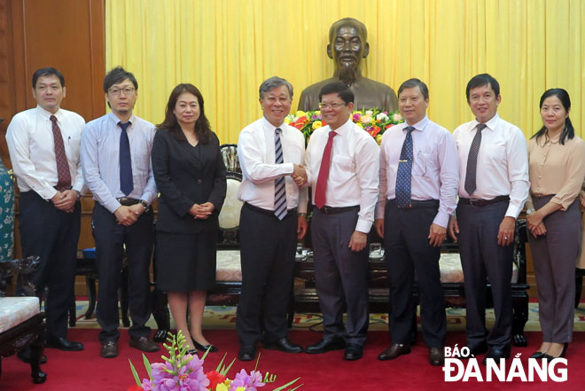 Deputy Secretary Tri (4th right) shaking his hand with Director Inanaga (4th left)