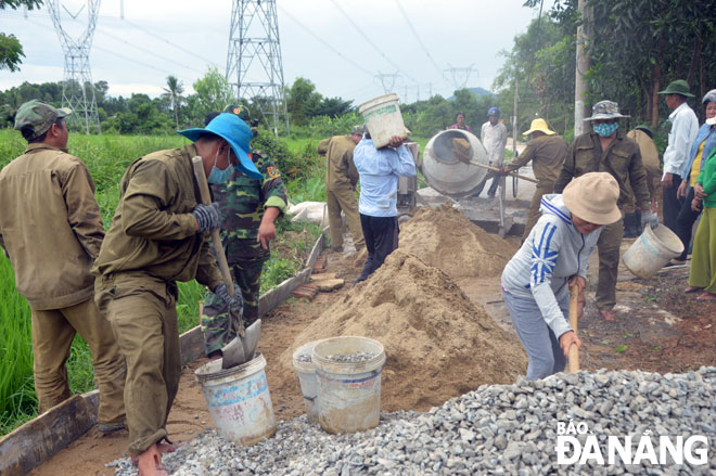 Lực lượng vũ trang thành phố giúp dân làm đường giao thông liên thôn, xây dựng mối đoàn kết chặt chẽ với nhân dân.