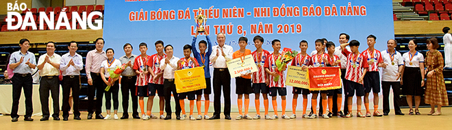 Đại diện lãnh đạo các đơn vị tổ chức và nhà tài trợ chụp ảnh lưu niệm cùng đội THCS Nguyễn Hồng Ánh, vô địch bảng đấu Thiếu niên.