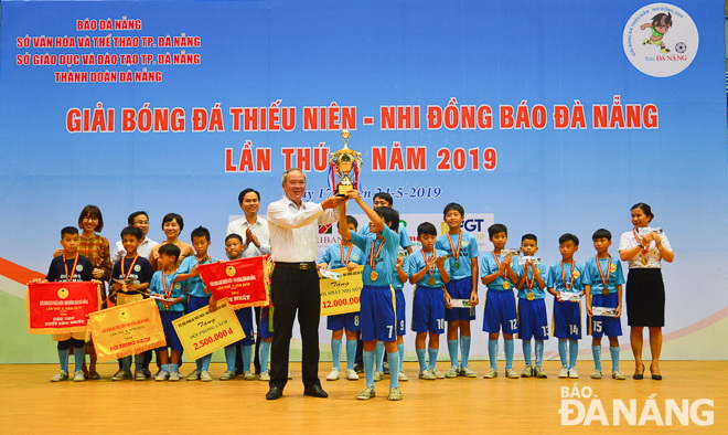 Mr Truong Cong Dinh, the DA NANG Newspaper Editor-in-Chief, awarding the champions trophy to Be Van Dan players