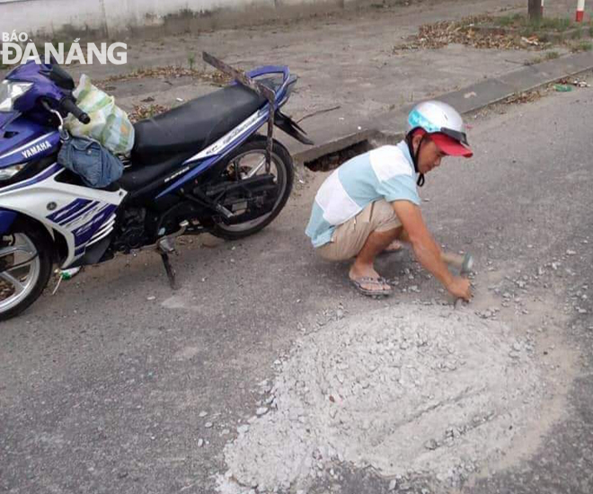 Người thanh niên làm việc rất tự nguyện khi thao tác đục tảng bê tông trên nền đường 