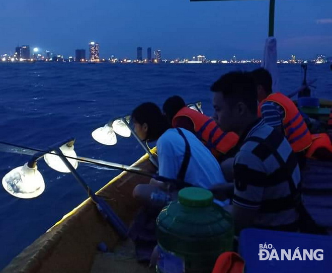 Du khách trải nghiệm câu mực đêm trên biển Đà Nẵng. Ảnh: L.L