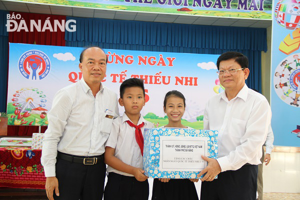 Deputy Secretary Tri (first right) presenting gifts to children in the Village of Hope