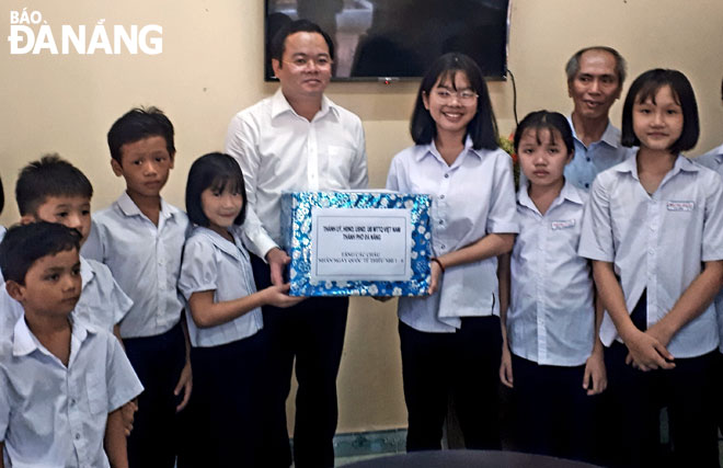 Phó Chủ tịch HĐND thành phố Lê Minh Trung (giữa) tặng quà cho trẻ em Gia đình số 3, Trung tâm Bảo trợ trẻ em đường phố thành phố Đà Nẵng.