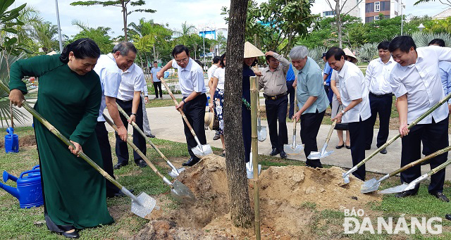 Vice Chairwoman Phong (1st left), Secretary Nghia (2nd left) and other people together planting a souvenir tree in the campus of the Children's Cultural Palace.