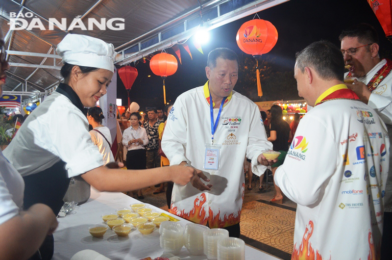 Không chỉ nấu nướng, phục vụ du khách, các đầu bếp còn giao lưu, thưởng thức món ăn của nhau. Trong ảnh, các đầu bếp đang thức thức món chè Singapore.
