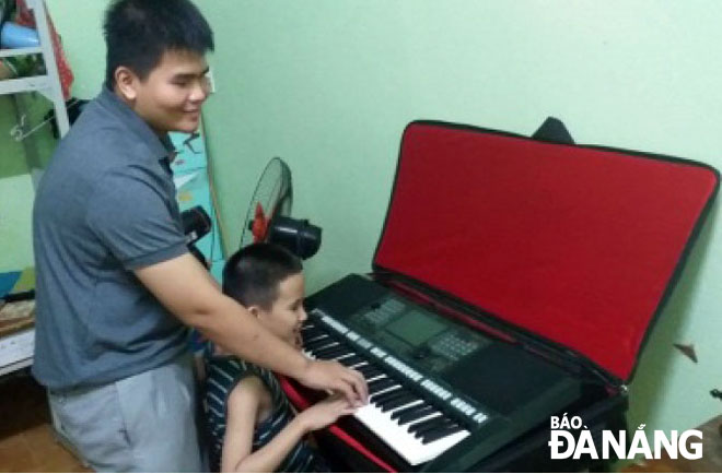 Vo Van Nhat teaching the organ to a disabled child