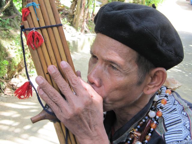 An ethnic man plays an musical instrument in a village of central Viet Nam. 