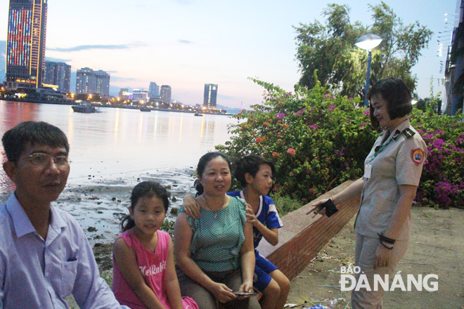 A female urban rule team member reminding local residents not to liter whilst watching fireworks performances