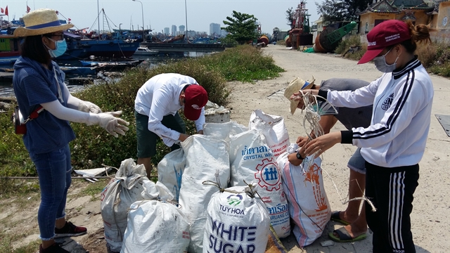 A group of volunteers collect waste at a fishing port in Da Nang city. VNS Photo Công Thành 