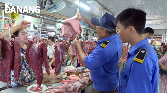 Quận Ngũ Hành Sơn tổ chức Đoàn kiểm tra liên ngành kiểm tra các hộ kinh doanh thịt heo tại các chợ trên địa bàn. TRONG ẢNH: Kiểm tra chất lượng thịt heo tại chợ Bắc Mỹ An.