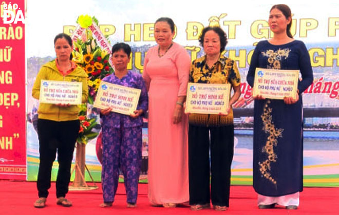 Chủ tịch Hội LHPN phường Hòa Hải Mai Thị Thuận (giữa) trao tiền hỗ trợ sinh kế và sửa chữa nhà cho hội viên phụ nữ nghèo.