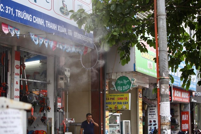 Nhiều cửa hàng ở Hà Nội phải sử dụng vòi phun sương để giảm nhiệt. (Ảnh: Minh Quyết/TTXVN)